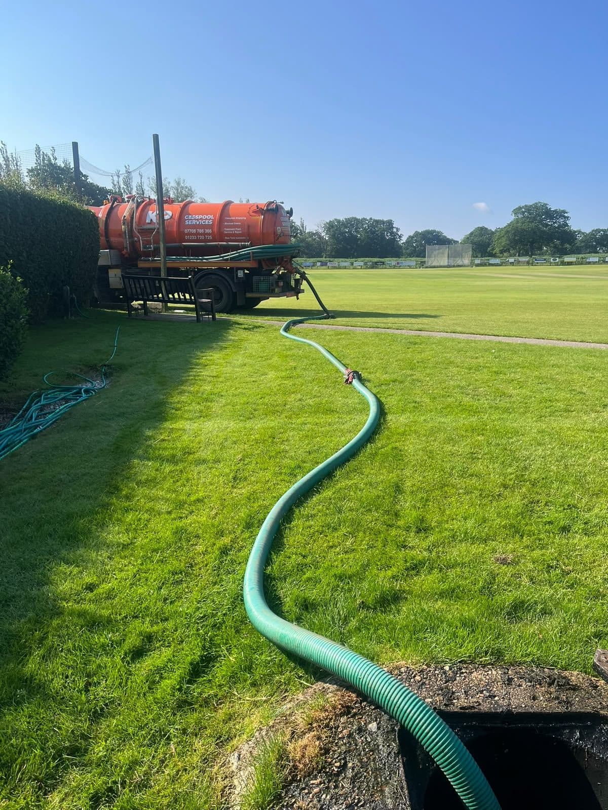 Long suction hose run from the tanker across a field to an open chamber