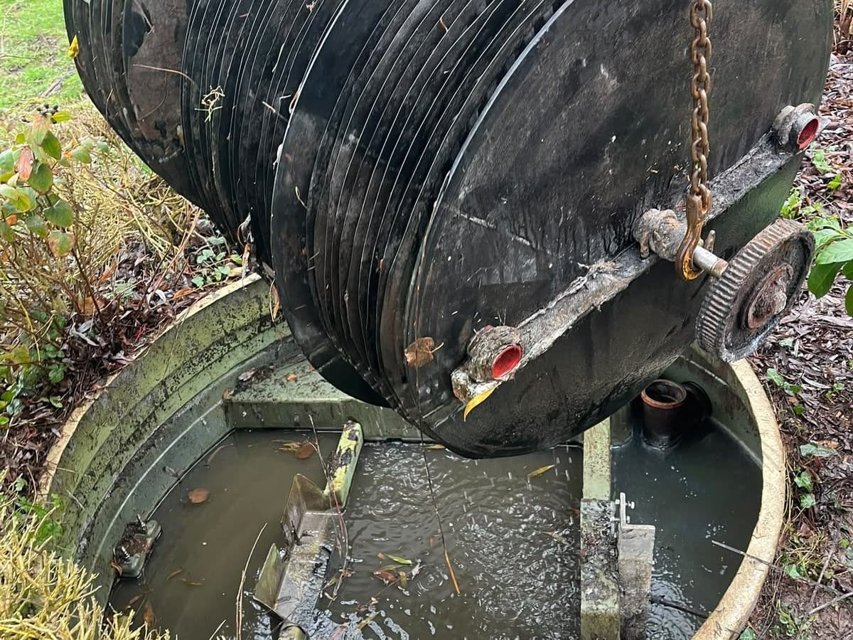 Treatment plant unit lifted out of its chamber on chains for servicing