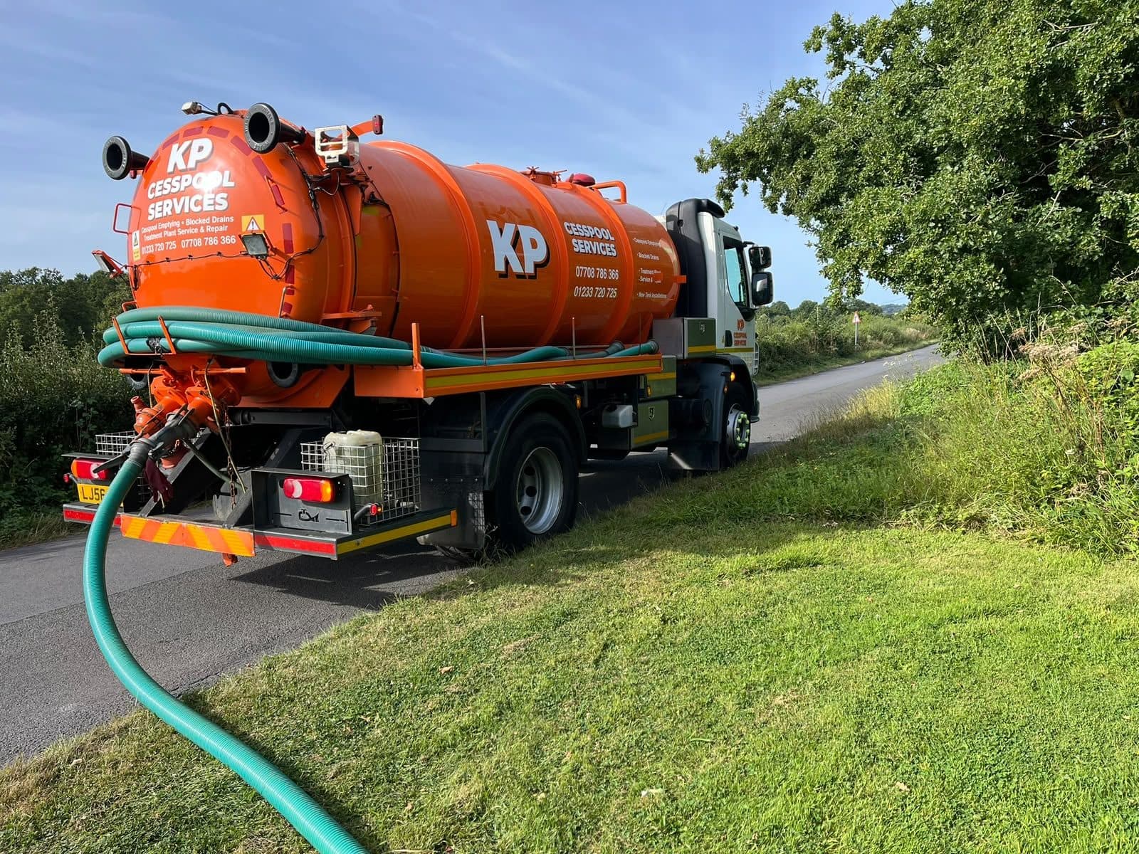 KP tanker parked on a narrow country lane with the suction hose run out to a tank