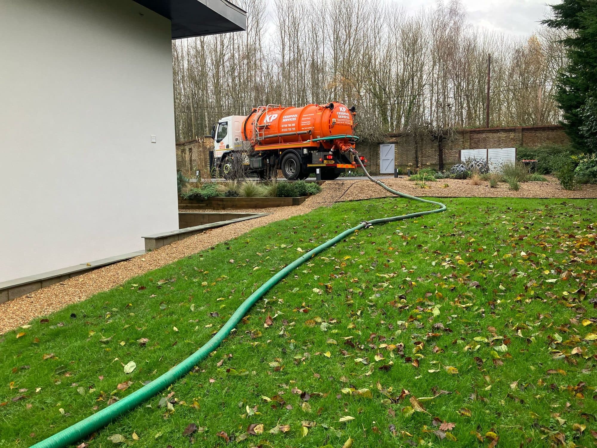 Suction hose run across a lawn from the KP tanker to a tank at a rural property
